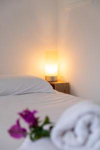 a bedroom with a bed with a lamp and purple flowers at GuestReady - Tranquil Retreat in Nature's Embrace in São Vicente