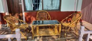 three wicker chairs and a table on a porch at Kabilas Resort and Funpark in Upardāng Garhi
