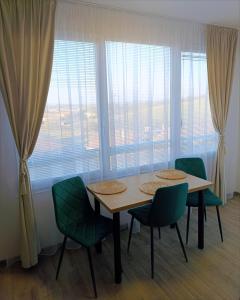 a table and chairs in a room with a large window at Grand Apartman - 5 Star Luxury Podhajska Apartman in Podhájska