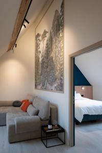a living room with a couch and a bed at La Ferme de la Gloriette - Gîte & Spa in Trieu de Frêne