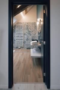 a bathroom with a wooden floor and a mirror at La Ferme de la Gloriette - Gîte & Spa in Émines