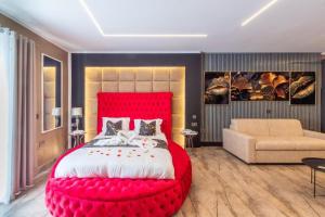 a bedroom with a large red bed and a couch at Ruby's - By Solea Holiday Homes in St Julian's