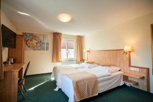 a hotel room with a bed and a desk at Hotel Restaurant Adler in Westhausen +51 photos
