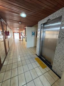 a hallway with a stainless steel door in a building at Hotel Veleiro in Florianópolis +8 photos