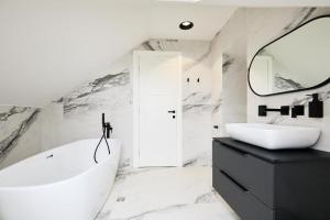 a bathroom with a tub and a sink and a mirror at Tudisi Loft Room in Dubrovnik