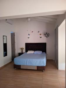 sypialnia z łóżkiem z niebieską pościelą i motylami na ścianie w obiekcie Habitacion 201 Casa Luz El Rodadero w mieście Gaira