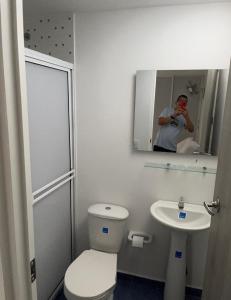 mężczyzna robiący zdjęcie łazienki z toaletą i umywalką w obiekcie Habitacion 201 Casa Luz El Rodadero w mieście Gaira