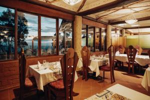 a restaurant with white tables and chairs and windows at Java Boutique Hotel in Lushoto