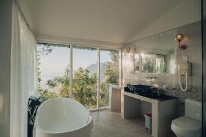 a bathroom with a tub and a sink and a window at Java Boutique Hotel in Lushoto +28 photos