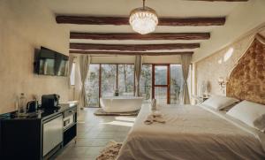a bedroom with a large bed and a bath tub at Java Boutique Hotel in Lushoto