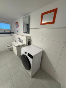 a bathroom with a washing machine and a toilet at NEU renoviertes Apartment 3 Zimmer 4 Boxspringbetten moderne Küche und vieles mehr in Löhne