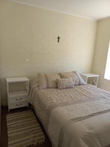 a bedroom with a bed and a cross on the wall at Apart home TALCA - casa amoblada 8 personas in Talca +4 photos