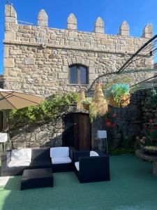 a stone building with a patio with furniture in front of it at Solar Sampaio e Melo in Trancoso
