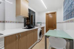 a kitchen with a washer and dryer at Las Canteras Coastal Rooms - Only adults in Las Palmas de Gran Canaria