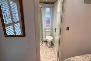 a bathroom with a toilet and a window at 2 Bed Lodge-Sleeps 4-Valley View-Pet Friendly in Windermere +25 photos