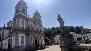 un viejo edificio con una estatua delante de él en Caires Urban Nest, en Braga