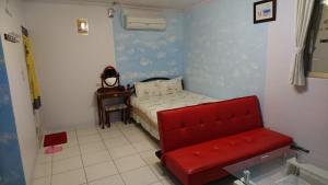 1 dormitorio pequeño con 1 cama y 1 silla roja en Wujie My Home en Wujie