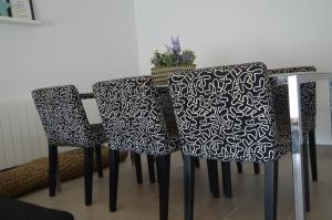 a table with three chairs and a vase on it at LLOGUER30 El Far, swimming pool and parking in Sant Feliu de Guixols