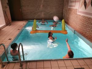 a group of people playing in a swimming pool at Zimmer am Deich in Weyhe
