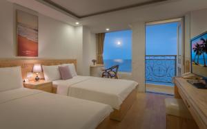 une chambre d'hôtel avec deux lits et une grande fenêtre dans l'établissement Nang Vang Hotel Nha Trang, à Nha Trang 44 autres photos