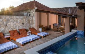 a patio with lounge chairs and a swimming pool at Awesome Home In Zastrazisce With Wifi in Zastražišće