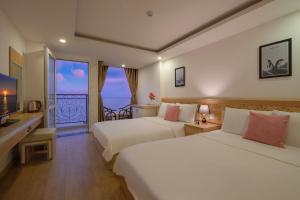 une chambre d'hôtel avec deux lits et un balcon dans l'établissement Nang Vang Hotel Nha Trang, à Nha Trang
