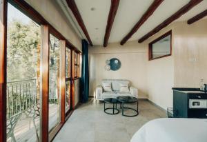 a room with a bed and a couch and a balcony at Java Boutique Hotel in Lushoto