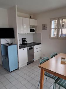 a kitchen with a refrigerator and a table with chairs at Proche plage à Gassin, G35 in Gassin