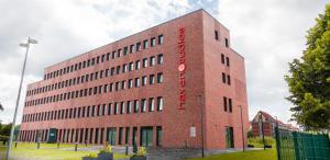 a brick building with a red sign on it at havenstudios Bremerhaven in Bremerhaven