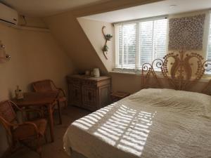 a bedroom with a bed and a table and a window at Modern Cozy Asian Style bedroom with Kingsize Spa bath in Westbeemster +19 photos