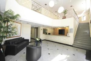 a lobby with a black couch and a staircase at Bienal Suites Ibirapuera c/ Sacada - UH 1207 in São Paulo +18 photos