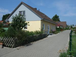 グラール・ミューリッツにあるApartment An der Büdnereiの塀の横の黄白家