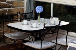 a table with plates and cups and a vase with blue flowers at Hotel Los Ángeles in Mar del Plata