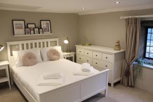 a bedroom with a white bed and a window at The Nook in Bakewell