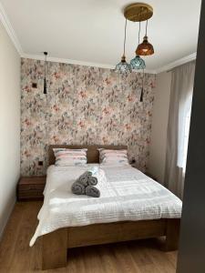 1 dormitorio con 1 cama con pared de flores en GabalaComfyHouse, en Gabala