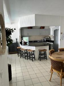 Una cocina con sillas y una mesa en una cocina. en Perissa 64, en Ballito