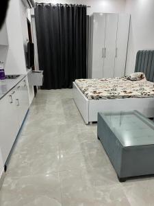 a room with two beds and a table in it at Golden palace studio in Noida +10 photos