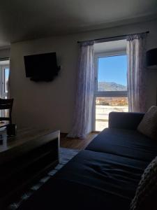a living room with a couch and a large window at Ferienmaisonette Purpurbuche in Reutte
