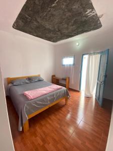 a bedroom with a bed and a wooden floor at Pensão CasaDanilo in Portela