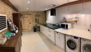 a kitchen with a washing machine and a microwave at Le Vert Buisson in Cartigny-lʼÉpinay