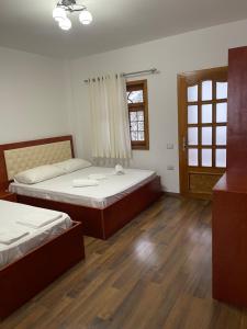 two beds in a room with wooden floors at Burimi i Valbones in Valbonë