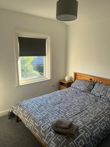 Un dormitorio con una cama grande con ventana. en Chestnut House, en Southport