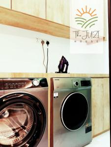 a washer and a washing machine in a kitchen at The Juzi House - private pool homestay in Kuala Terengganu +19 photos