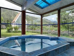 a pool in a house with a view of the mountains at Hotel Boutique La Caballeriza in Quillacollo