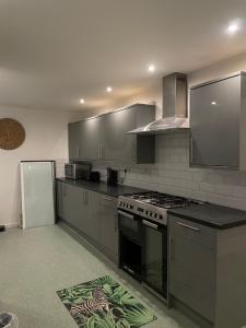 une cuisine avec une cuisinière et un réfrigérateur dans l'établissement Musden Walk individual rooms, à Manchester