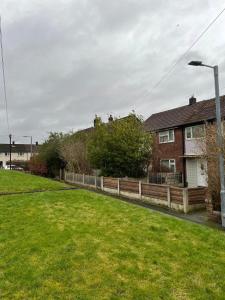 une maison avec une clôture en bois dans une cour dans l'établissement Musden Walk individual rooms, à Manchester