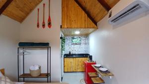 a kitchen with wooden ceilings and a counter in a room at Chalés do Zaney - Paraty in Paraty