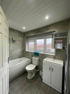 une salle de bains avec toilettes, baignoire et lavabo dans l'établissement Musden Walk individual rooms, à Manchester 25 autres photos