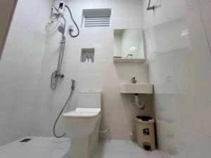 a white bathroom with a shower and a toilet at White Water Inn in Muli +17 photos