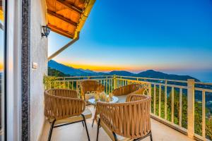 Un balcón con mesa y sillas con vista. en Alaya Stays 2 BHK Villa With Scenic views - Peace, en Bhimtal